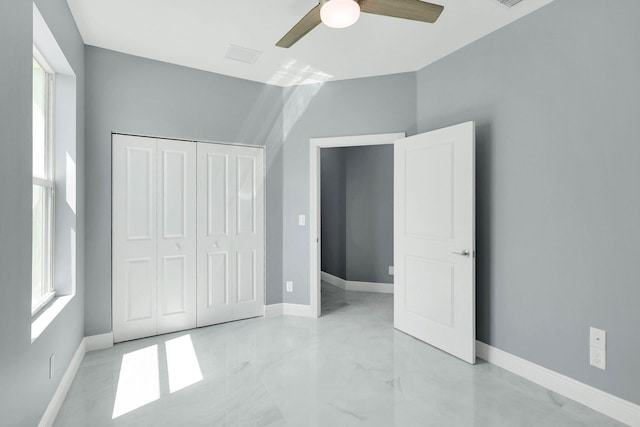 unfurnished bedroom with ceiling fan and a closet