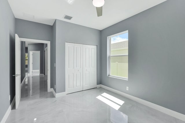 unfurnished bedroom featuring ceiling fan and a closet