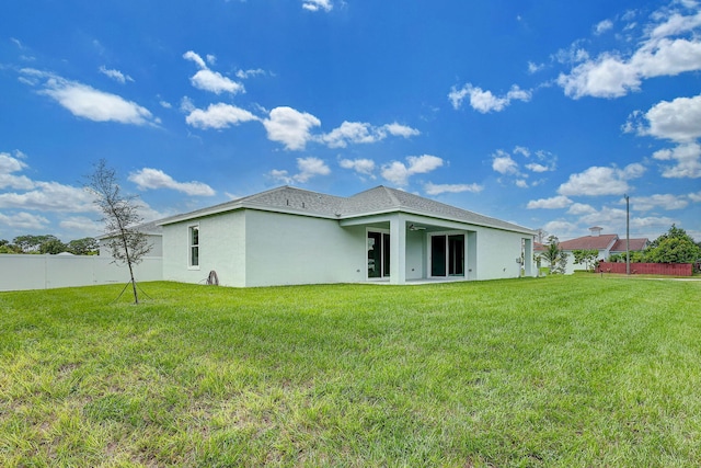 rear view of property with a lawn