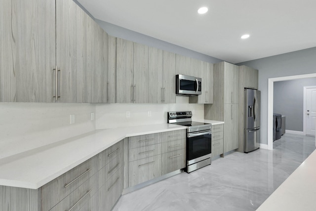 kitchen with light brown cabinets, stainless steel appliances, and separate washer and dryer