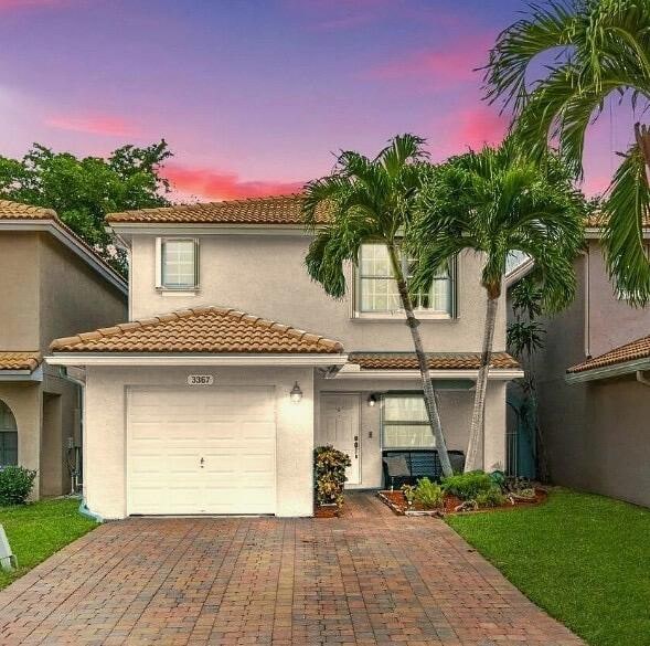 mediterranean / spanish house featuring a garage and a yard