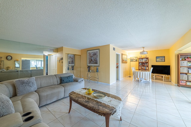 living room featuring a textured ceiling and light tile patterned floors