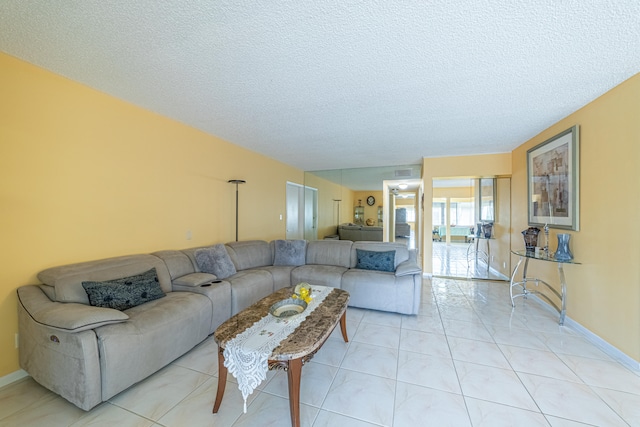 living room with a textured ceiling and light tile patterned floors