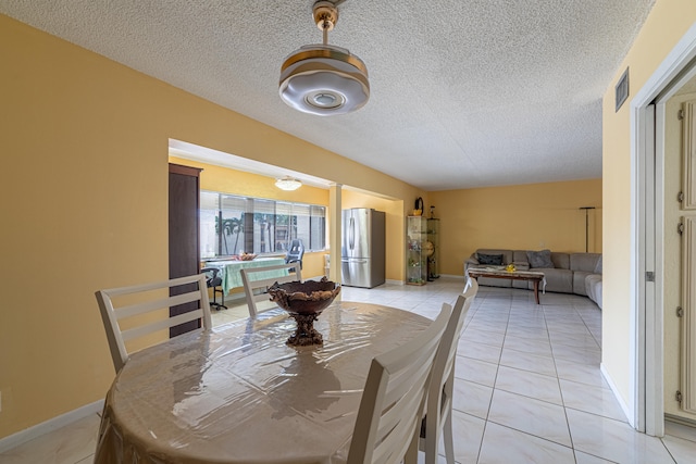 tiled dining space featuring a textured ceiling