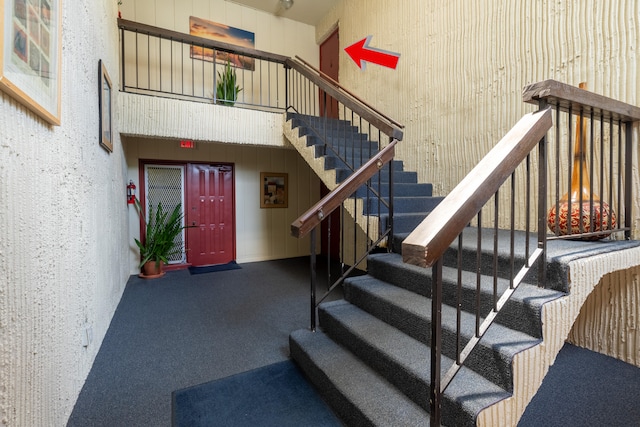 stairs featuring a high ceiling and carpet floors