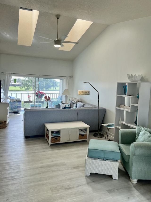 living room featuring light wood-type flooring, ceiling fan, and lofted ceiling