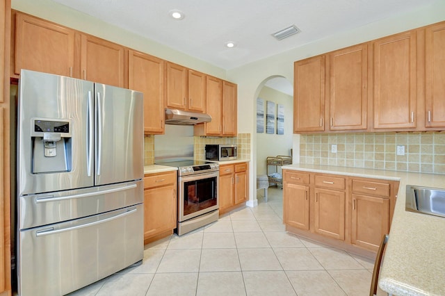 kitchen featuring light tile patterned flooring, stainless steel appliances, sink, and tasteful backsplash