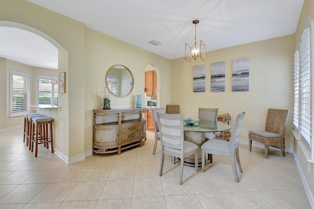 dining space featuring light tile patterned flooring and an inviting chandelier