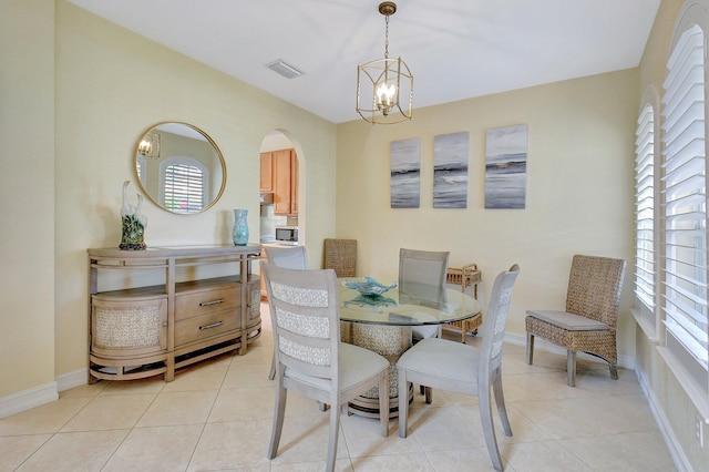 tiled dining area featuring a chandelier and a healthy amount of sunlight