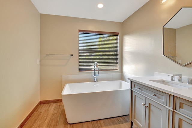 bathroom with vanity, wood-type flooring, and a bathtub