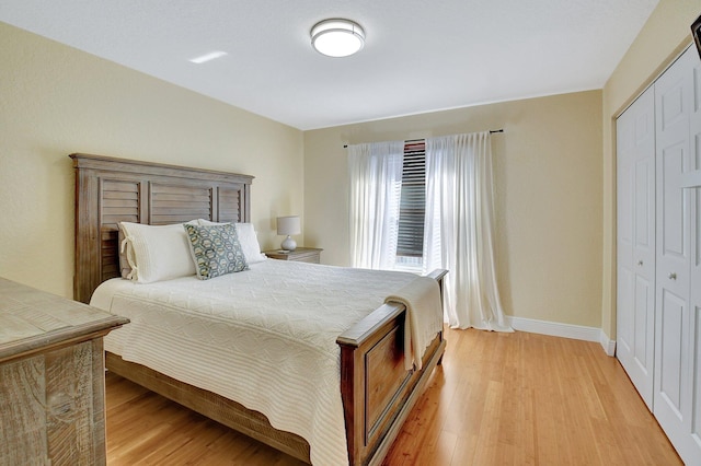 bedroom with light hardwood / wood-style flooring and a closet