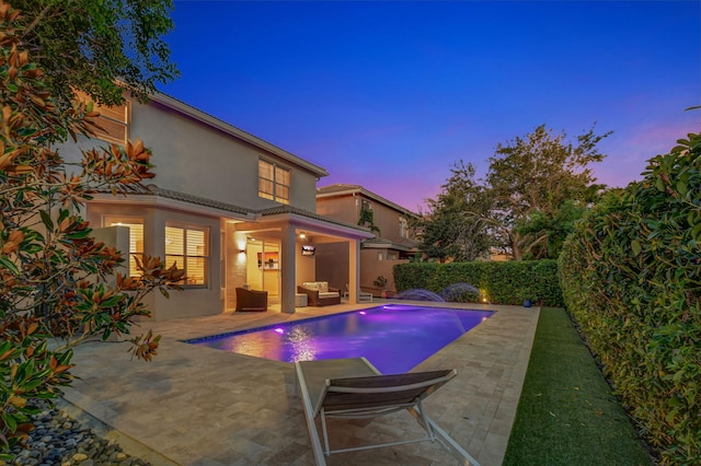 pool at dusk with a patio