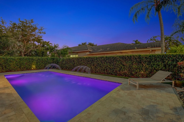 pool at dusk with a patio