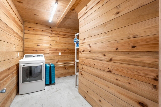 laundry room with wood walls and washer / dryer