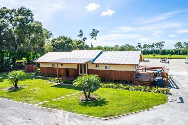 view of front of house with a front yard and a deck