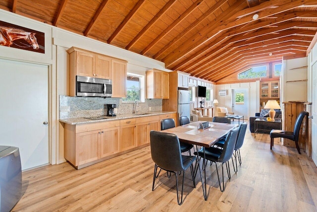 kitchen featuring lofted ceiling, light brown cabinets, appliances with stainless steel finishes, and light hardwood / wood-style floors