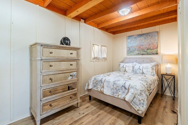 bedroom with light wood-type flooring, wood ceiling, and beamed ceiling