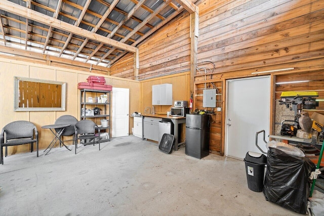 garage with stainless steel fridge, electric panel, and sink