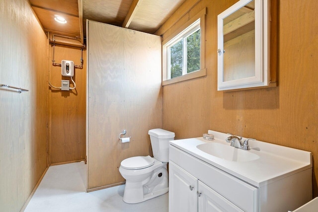 bathroom featuring wood walls, vanity, and toilet