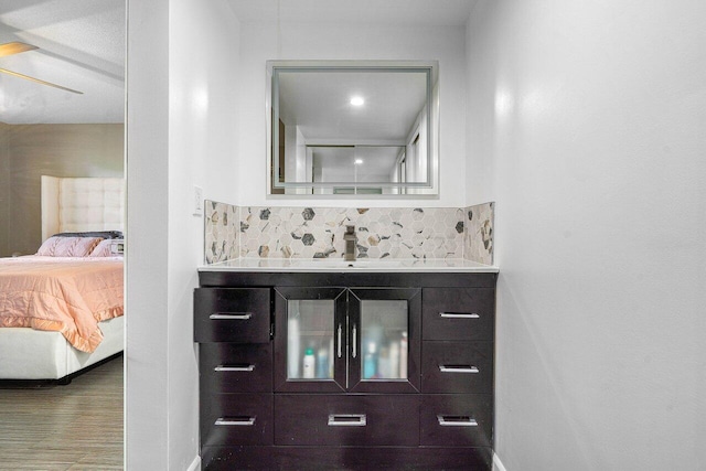 bathroom featuring tasteful backsplash, ceiling fan, and vanity