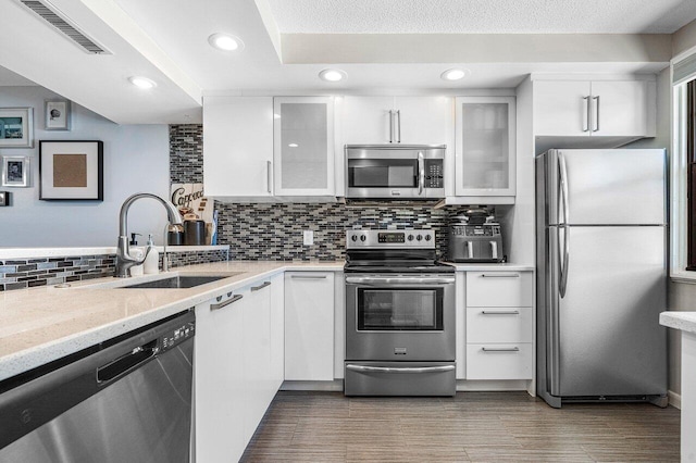 kitchen featuring appliances with stainless steel finishes, white cabinetry, and sink