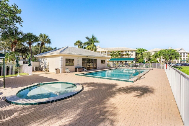 view of swimming pool with a patio and a hot tub