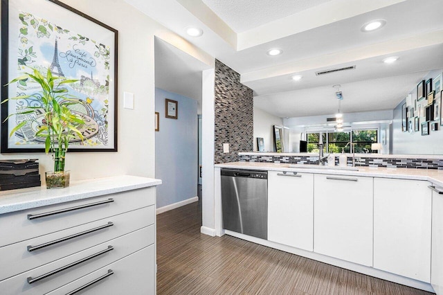 kitchen featuring light stone countertops, dishwasher, dark hardwood / wood-style floors, decorative backsplash, and white cabinets