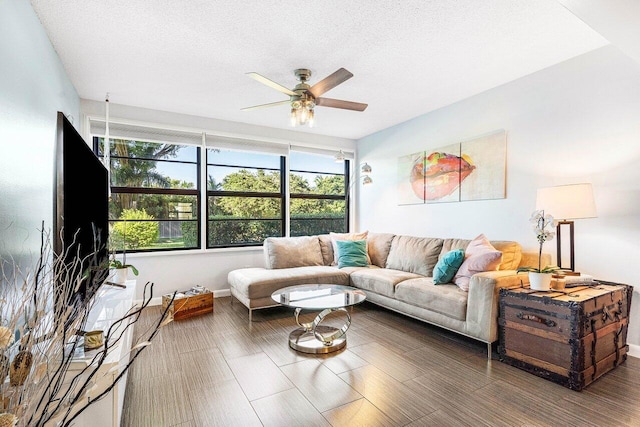 living room with ceiling fan and a textured ceiling