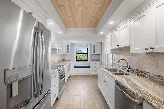 kitchen with sink, light hardwood / wood-style flooring, light stone countertops, appliances with stainless steel finishes, and white cabinetry