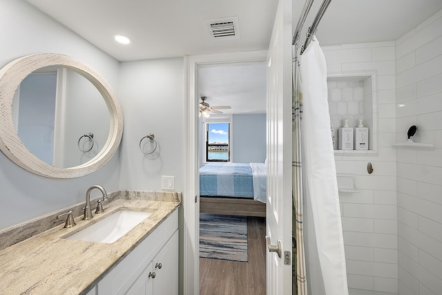 bathroom featuring a shower with curtain, ceiling fan, wood-type flooring, and vanity