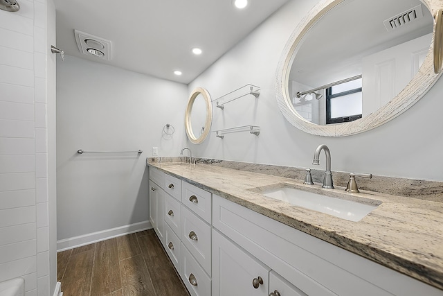 bathroom with a shower, vanity, and wood-type flooring