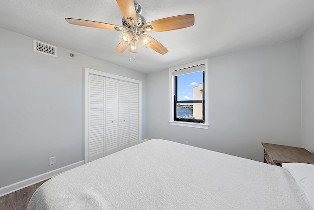 bedroom with ceiling fan, a closet, and dark hardwood / wood-style floors