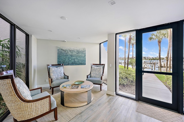 living area featuring light hardwood / wood-style floors and a wall of windows