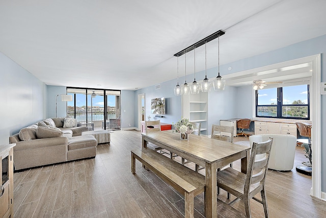 dining area featuring wood-type flooring and ceiling fan