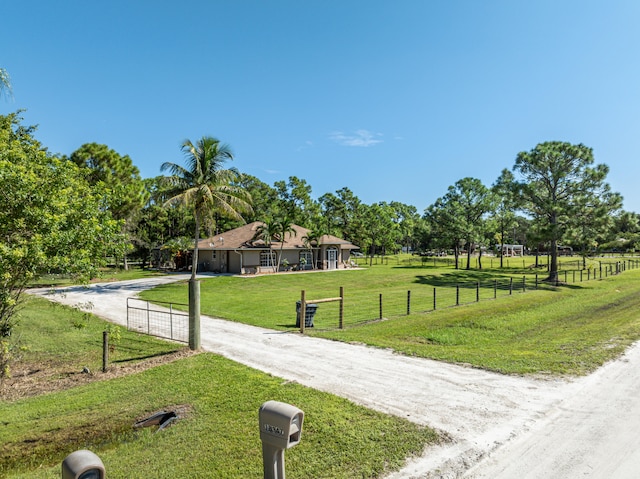 view of home's community with a rural view and a yard