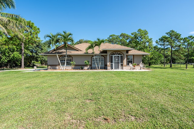 rear view of property featuring a lawn and a patio