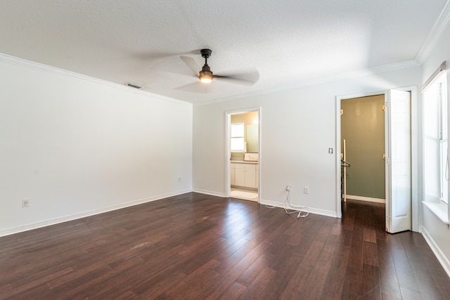 unfurnished bedroom with multiple windows, dark wood-type flooring, ceiling fan, and ensuite bath