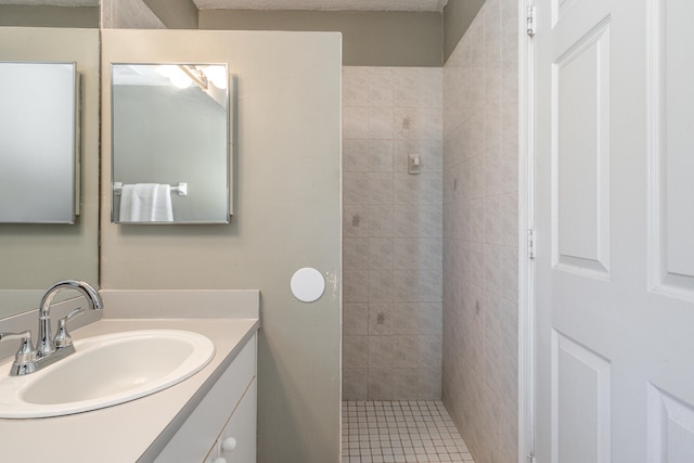 bathroom with vanity and tiled shower