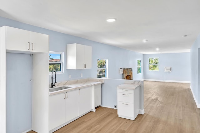 kitchen featuring white cabinetry, sink, and light hardwood / wood-style floors