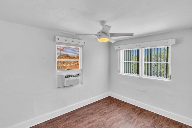 empty room featuring wood-type flooring, cooling unit, ceiling fan, and a healthy amount of sunlight