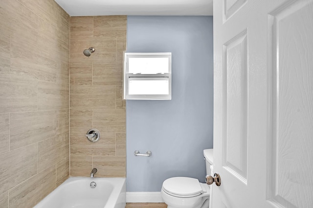 bathroom featuring toilet and tiled shower / bath