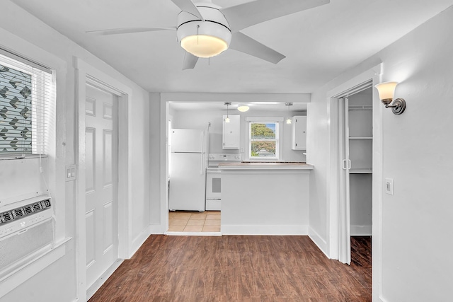 kitchen with pendant lighting, white cabinets, white refrigerator, ceiling fan, and wood-type flooring