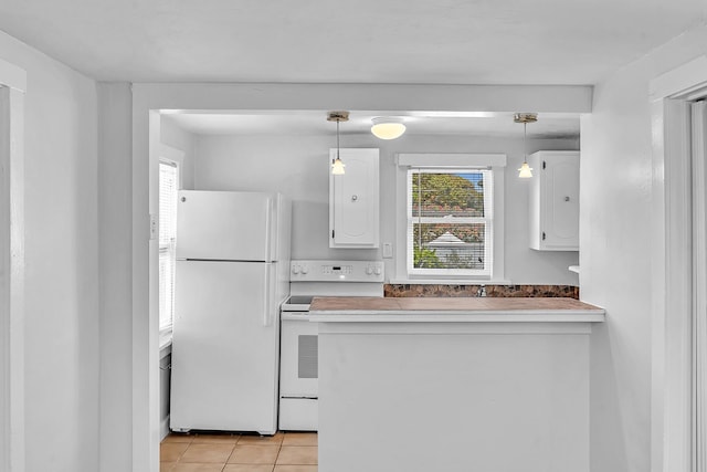 kitchen featuring pendant lighting, white cabinets, light tile patterned flooring, and white appliances