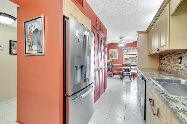 kitchen featuring ceiling fan, light tile patterned floors, a textured ceiling, backsplash, and appliances with stainless steel finishes