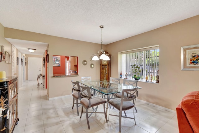 dining space featuring a textured ceiling and light tile patterned floors