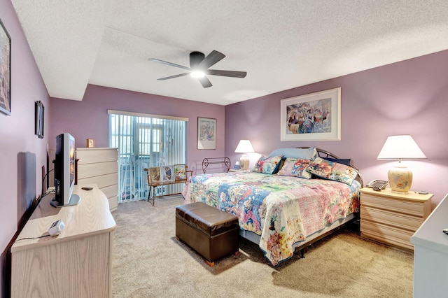 bedroom with a textured ceiling, ceiling fan, and light colored carpet