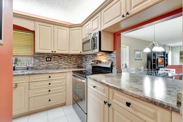 kitchen with pendant lighting, appliances with stainless steel finishes, plenty of natural light, and sink