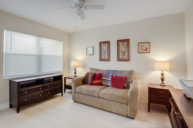 living room with a textured ceiling and ceiling fan