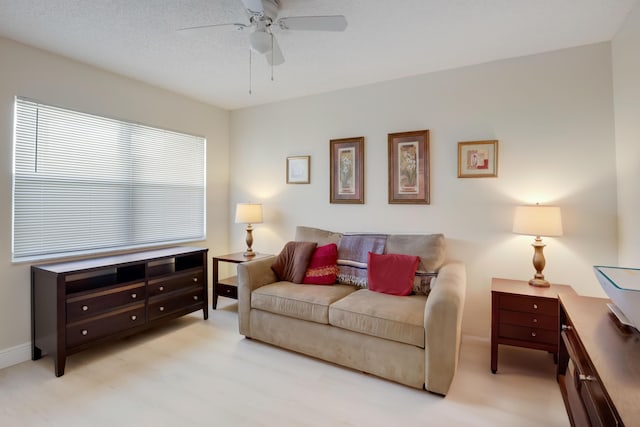 living room with ceiling fan and baseboards