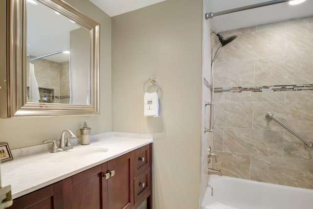 bathroom featuring tiled shower / bath and vanity